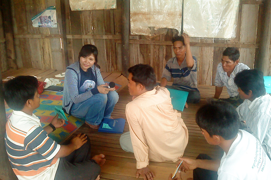 Photo of a woman interviewing Cambodian businesspeople.