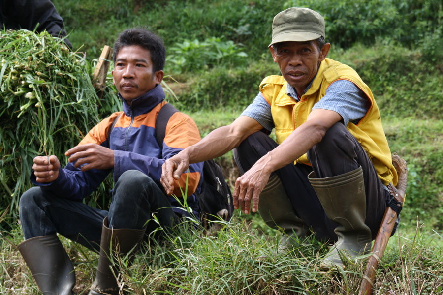 Photo of two men in cambodia at a fish farm.