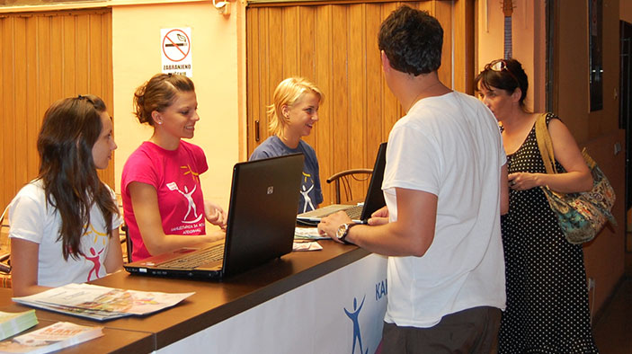 Photo of three youths working a counter in Serbia.