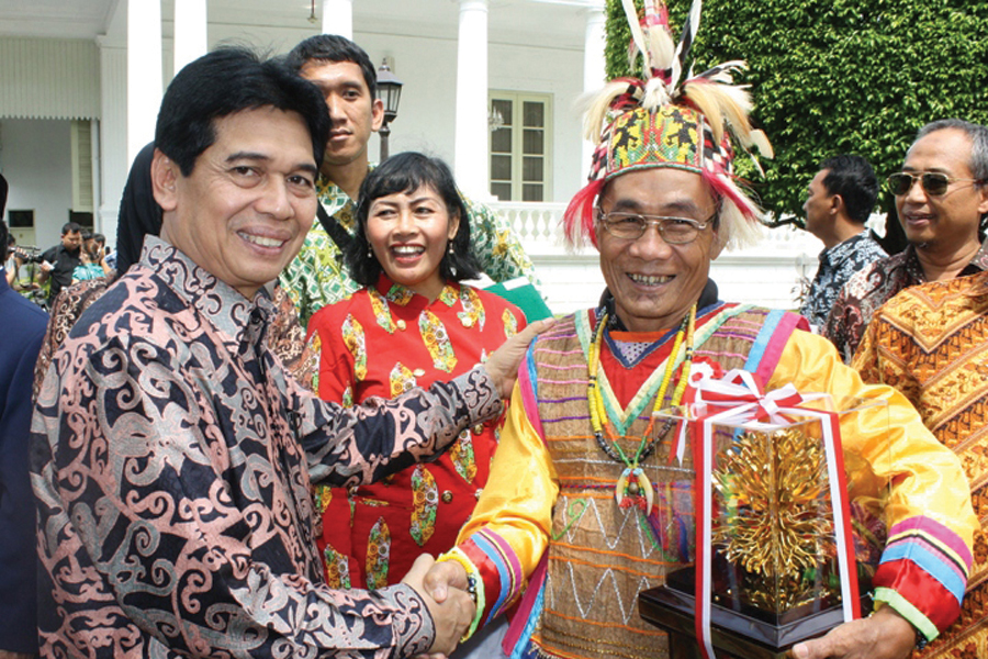 Photo of a handshake between representatives of the indigenous Dayak people of Wehena and the local government of East Kutai.