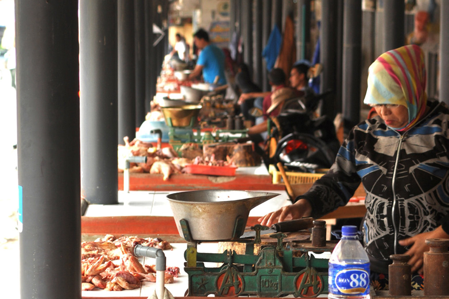 Photo of a customer using a poultry vendor scale at the Cipanas market.